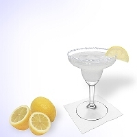 Margarita en una copa de margarita decorado con una rodaja de limón y con una pizca de azúcar o sal.