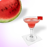 Watermelon Margarita en una copa de margarita decorado con un pedazo de sandía y con una pizca de azúcar o sal.